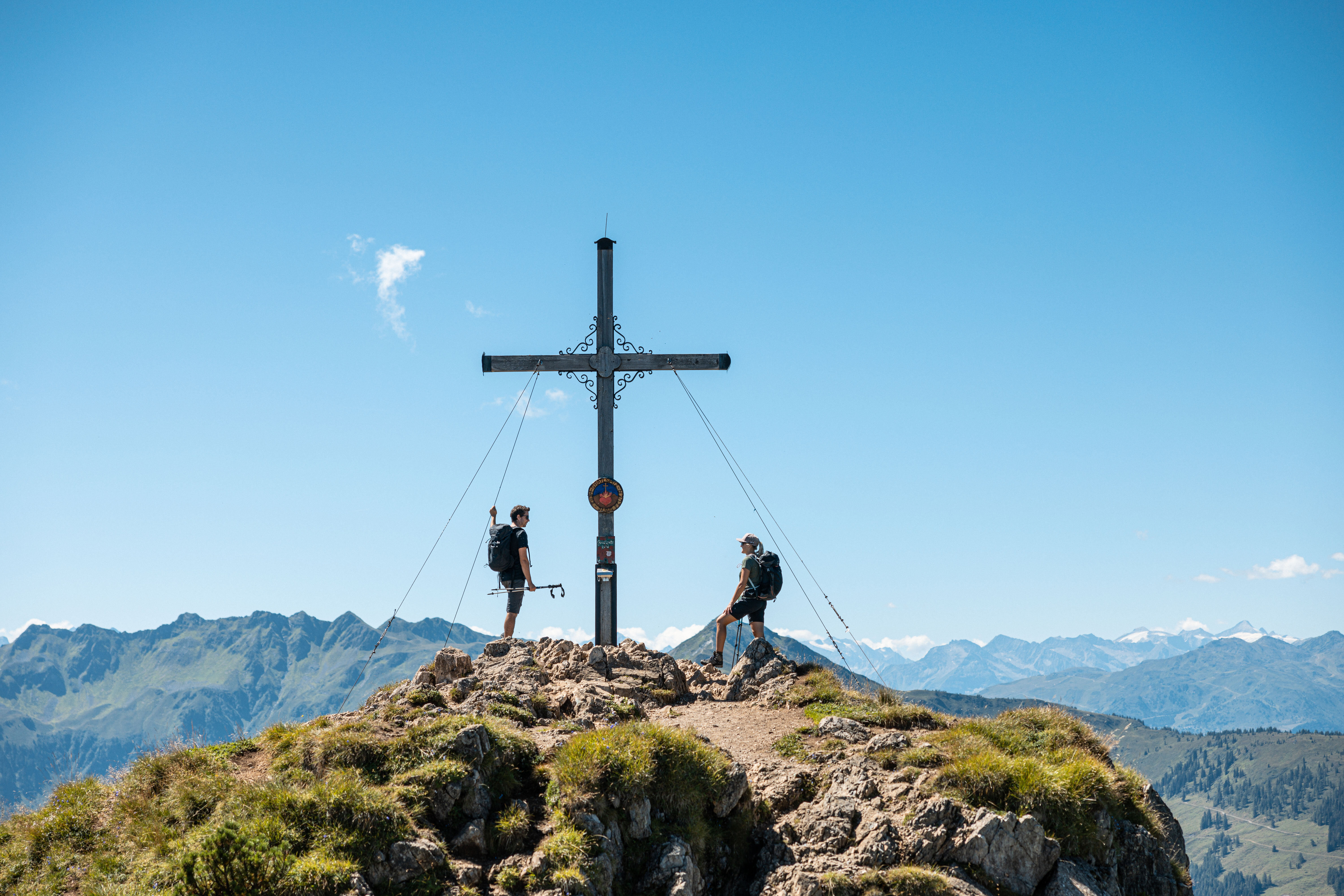 Ein Paar genießt gemeinsam den Gipfelsieg am Gipfelkreuz Gratlspitze im Alpbachtal  | © Alpbachtal Tourismus | shootandstyle 